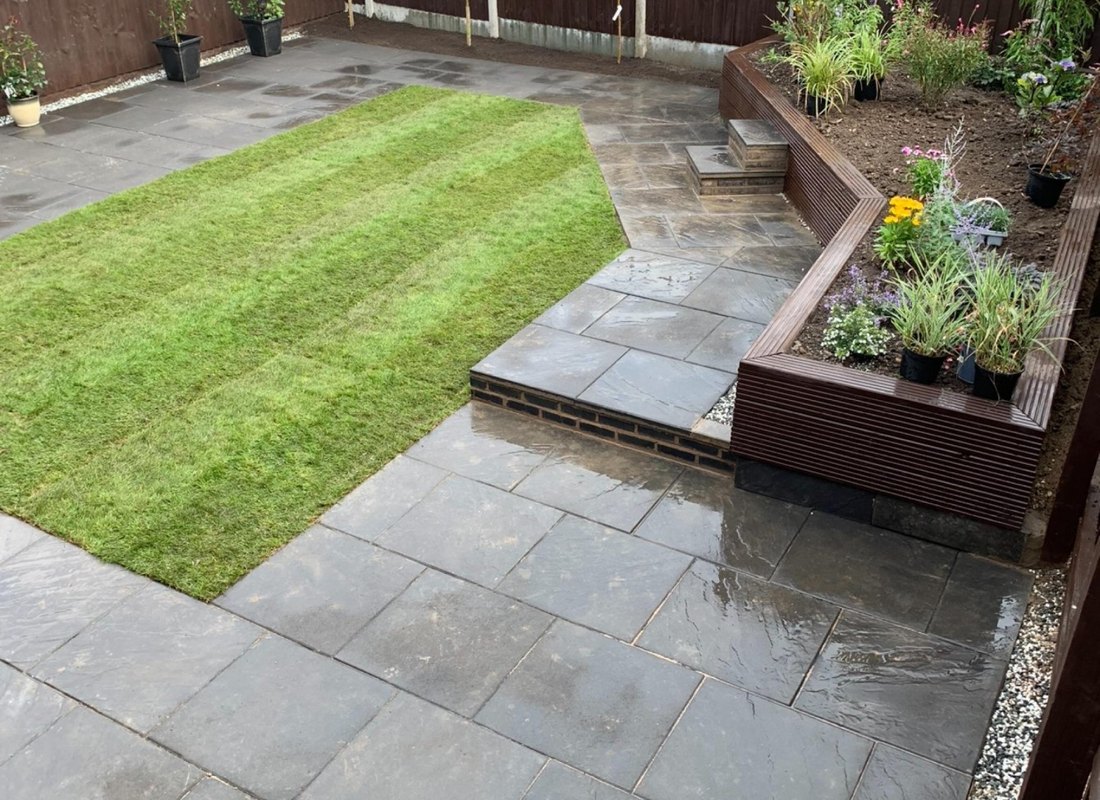 Dark stone patio, turf square and timber raised planter